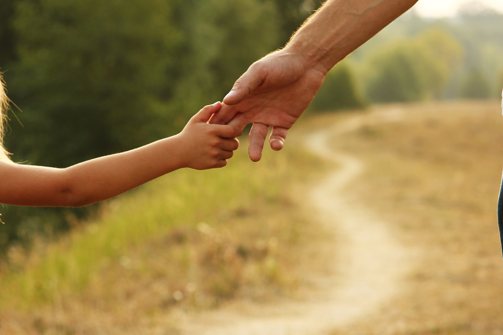 Cohabitating-With-Your-Ex-After-You-Split-parent holds the hand of a small child
