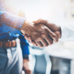 Discretionary Trusts Lawyer Des Moines, IA - Close up view of business partnership handshake.Concept two businessman handshaking process.Successful deal after great meeting.Horizontal,flare effect, blurred background.